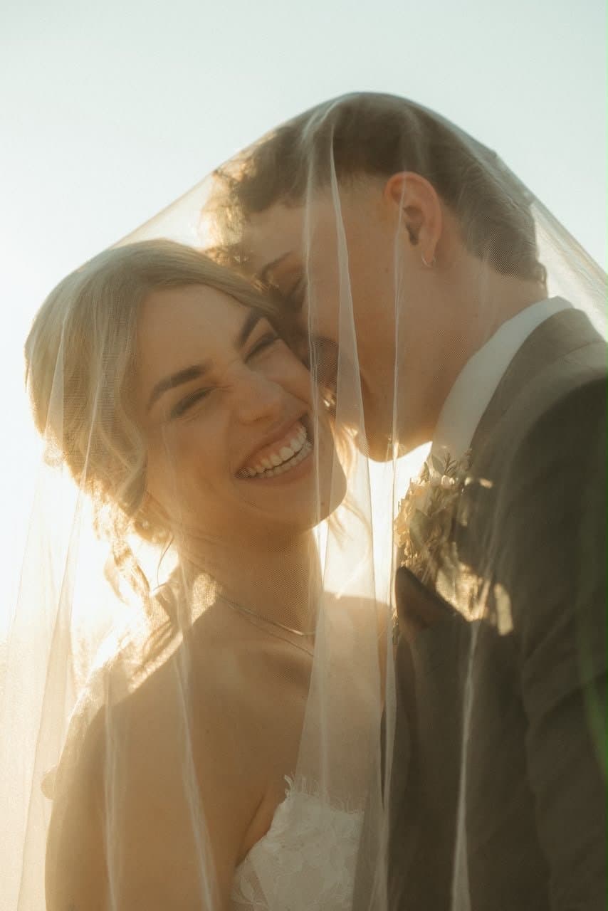 Emma laughing under the veil in golden light